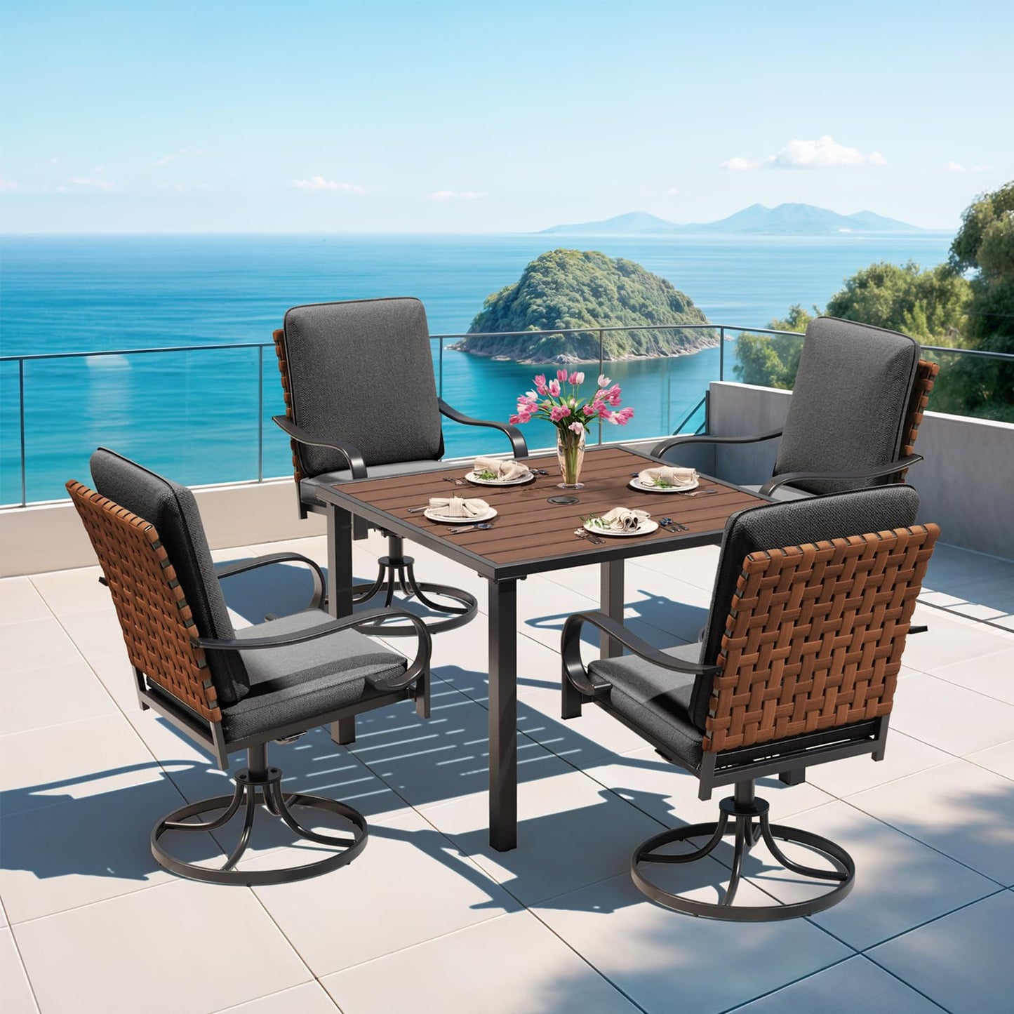 Outdoor patio set with table and chairs on a balcony overlooking the ocean.