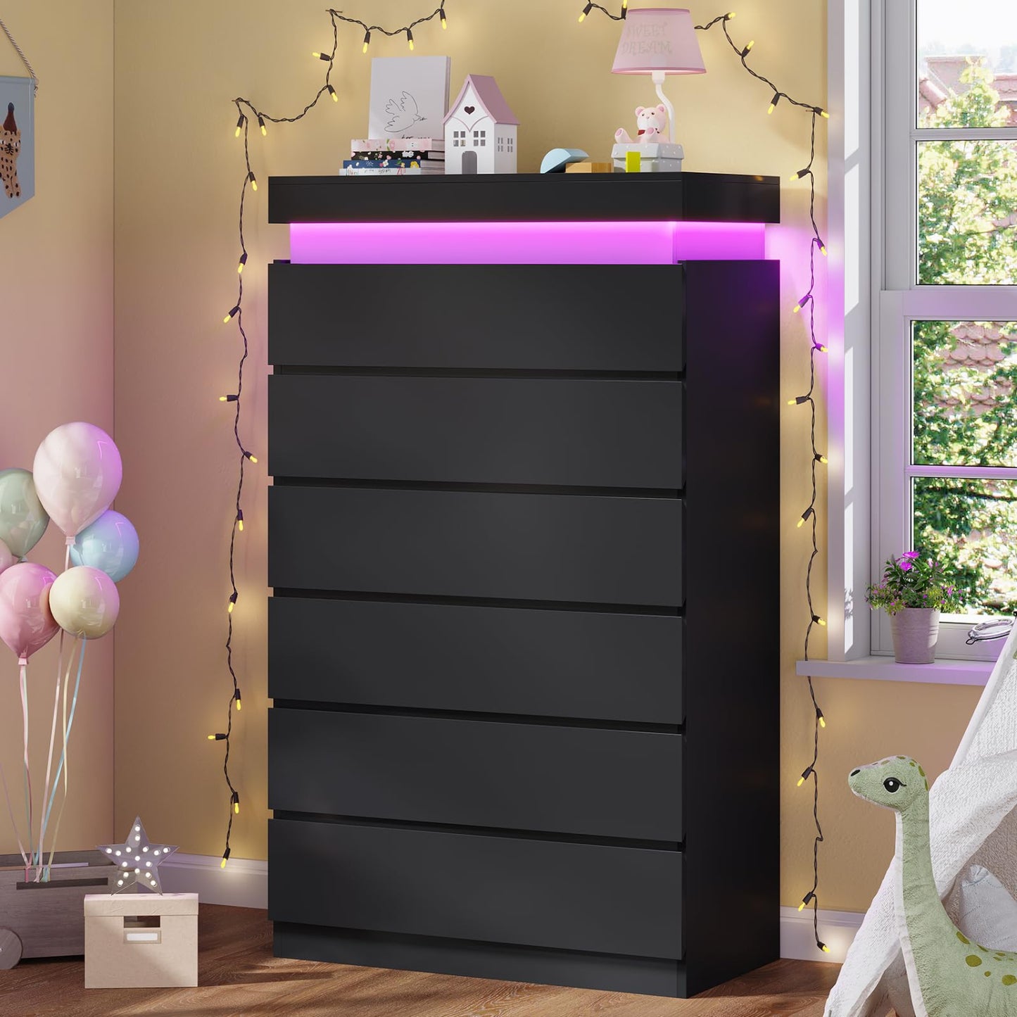 Black dresser with LED lighting in a room decorated with balloons and fairy lights.