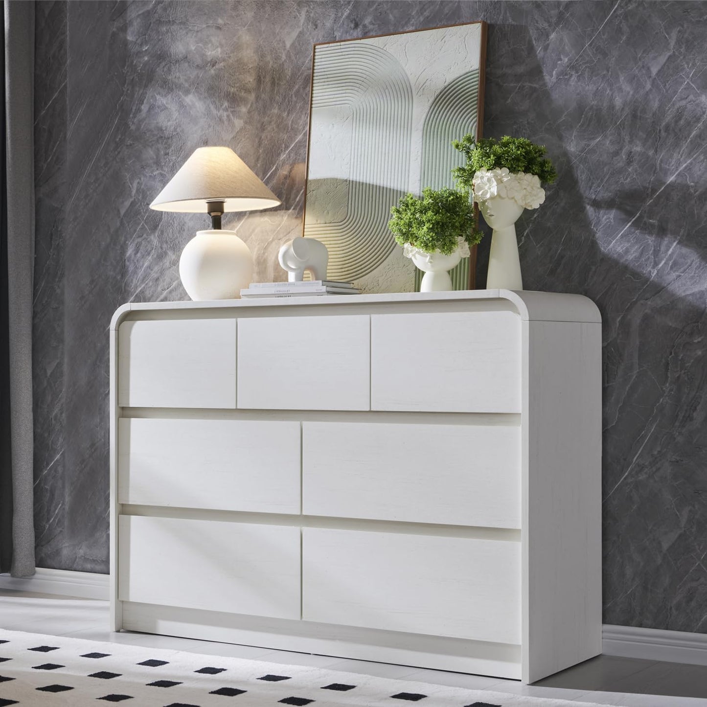 White dresser with decorative items against a gray marble wall