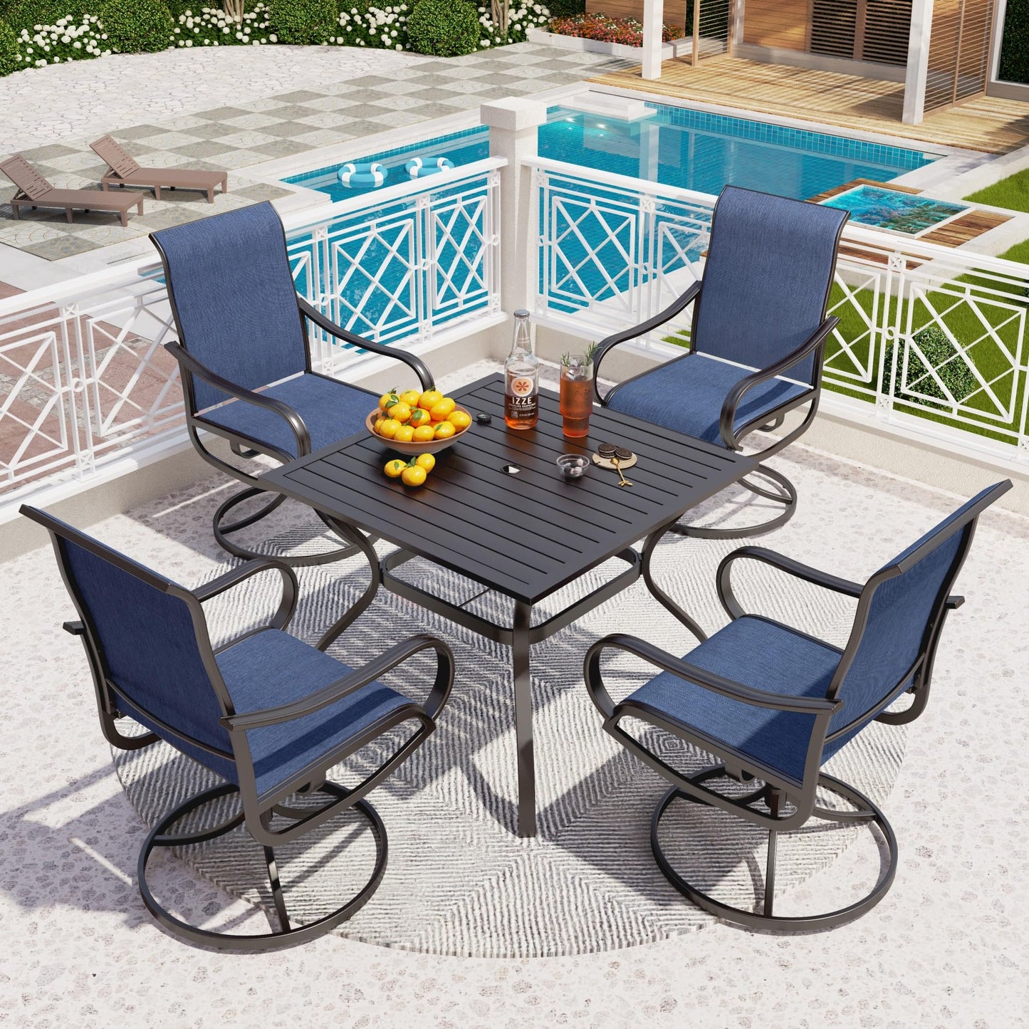 Outdoor patio set with four blue chairs and a table by a pool.