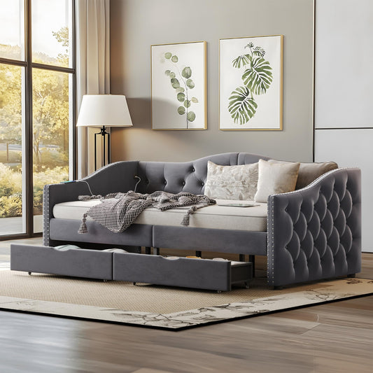 Gray tufted sofa bed in a room with green leafy artworks on the wall.