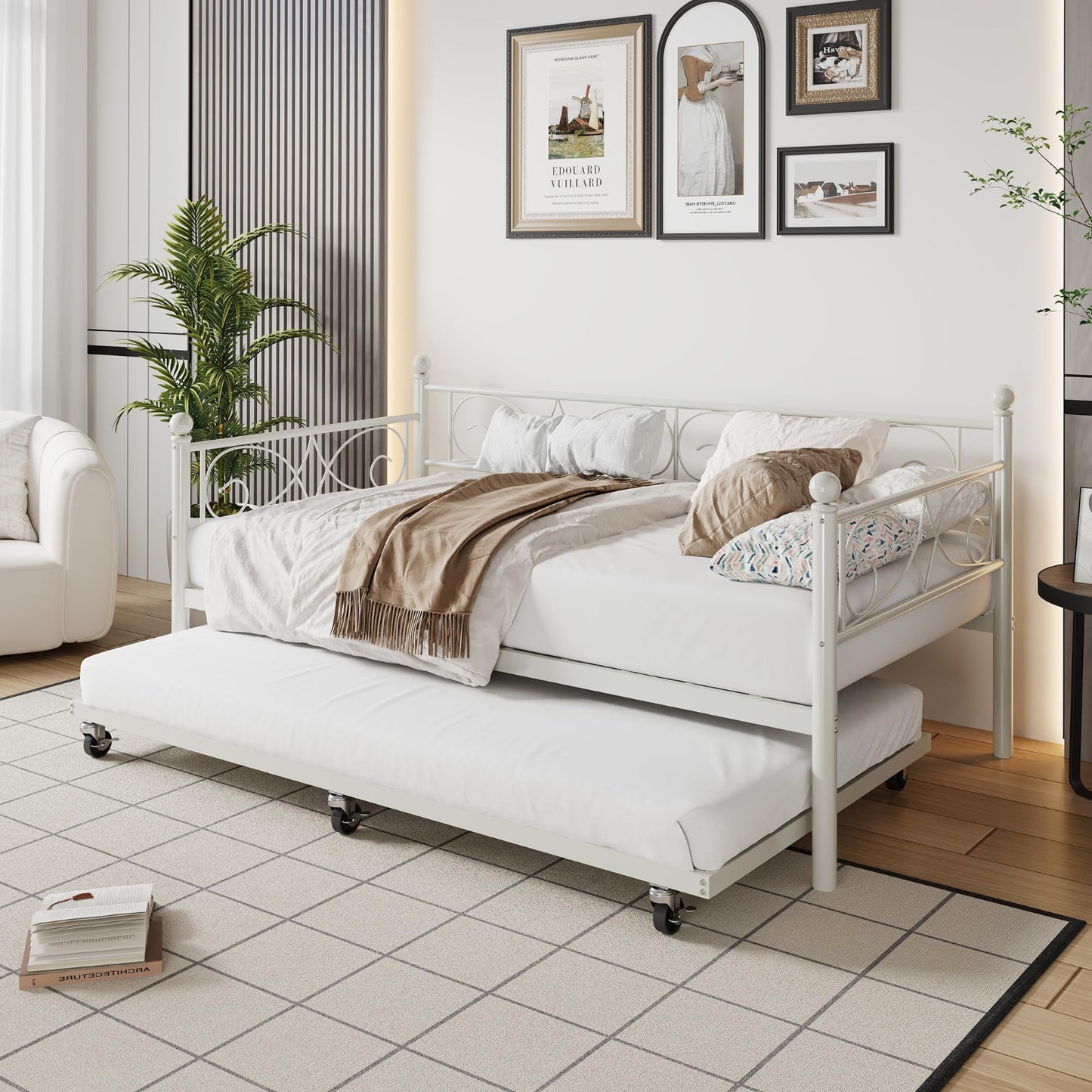 White metal bed with pull-out trundle in a room with decor elements.