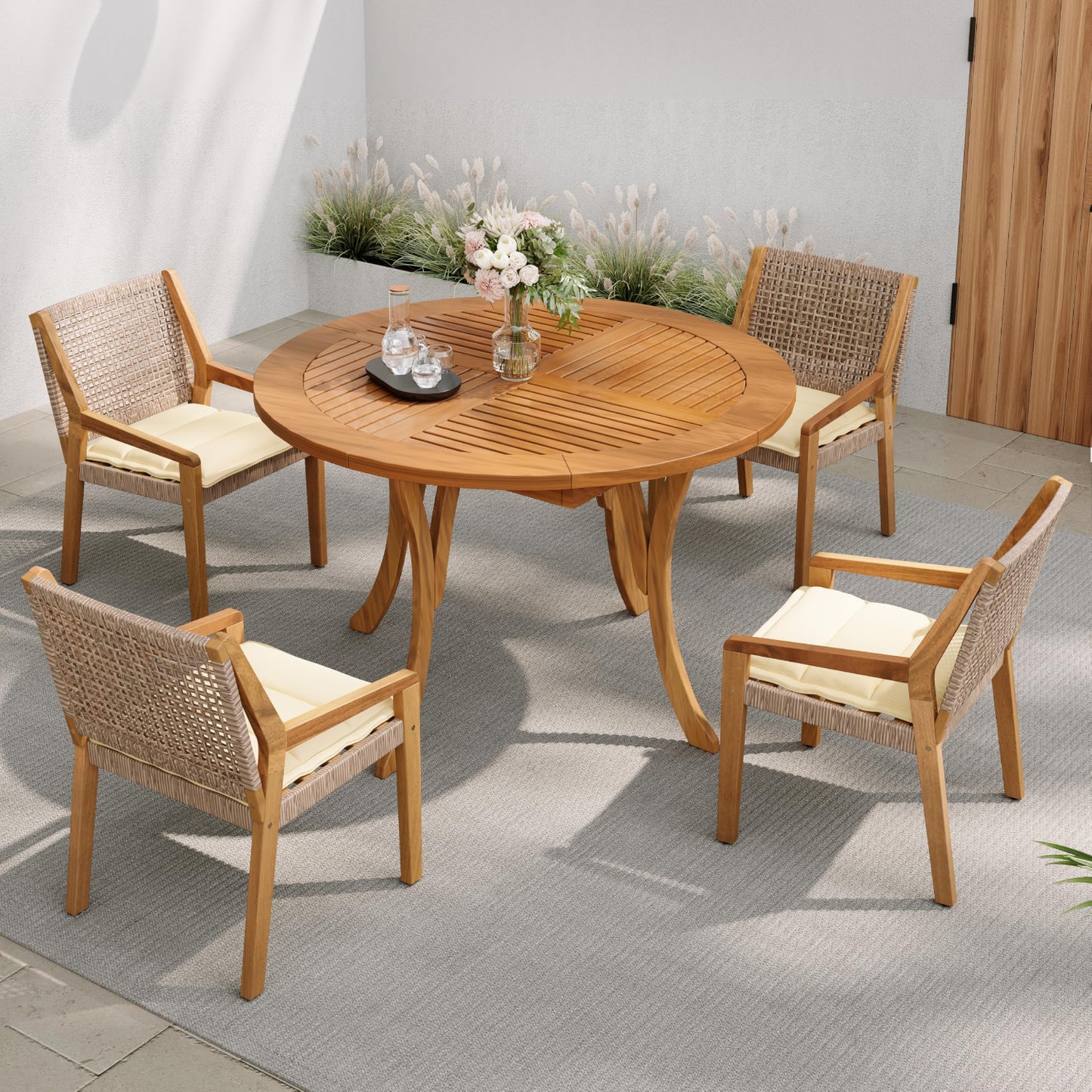 Wooden outdoor dining set with round table and four chairs on a patio.