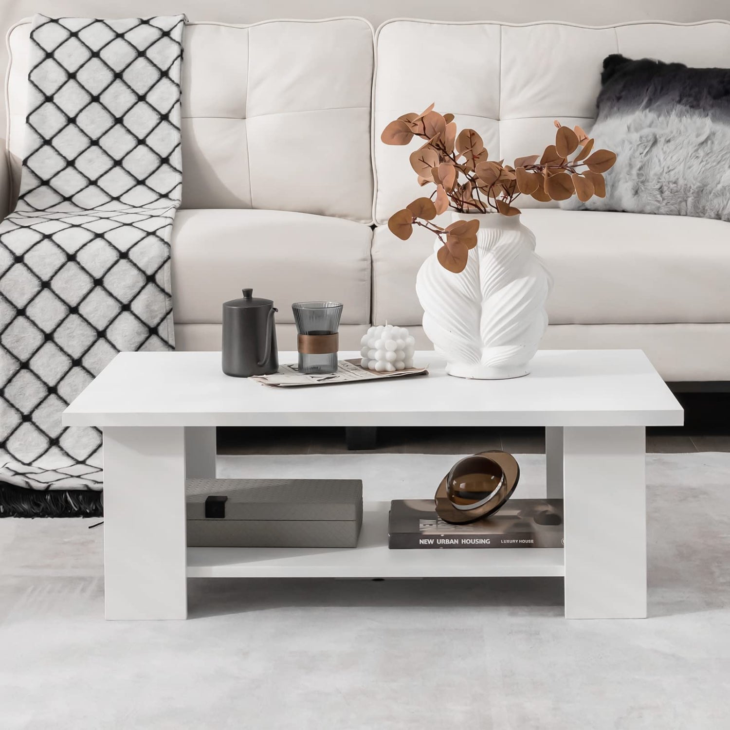 Modern living room with a white sofa, coffee table, and decorative items.