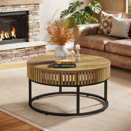 Round wooden coffee table with a black metal base in a living room setting.