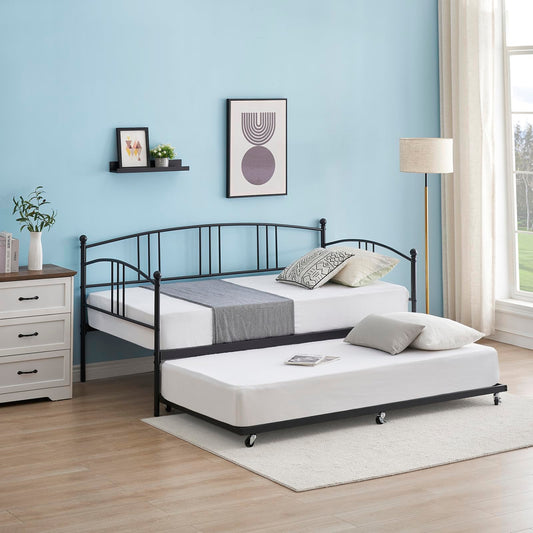 Bedroom with a black metal bed frame, white mattress, and decorative pillows against a light blue wall.